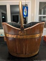 Front view showing brass handle, upper banding and wood slats