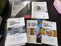 Stacks of assorted Royal Canadian Mint and Canada Post booklets displayed on table