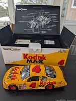 Model car displayed in front of original Team Caliber box