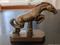 Left side view of bronze-tone jumping horse bookend