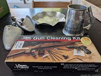 Group shot showing boxed gun cleaning kit, pewter tankard, aluminum shoe trees and hammered dish