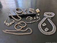 Overview of entire rhinestone jewelry lot on dark surface