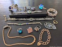 Full layout of assorted jewelry on table showing bracelets, rings, pendants, necklace, earrings