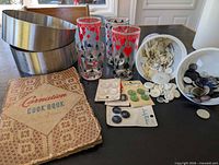 Group shot showing cookbook, pastry rings, four glasses, buttons
