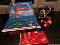 All three items: Rescue Pack open showing internal trays, Toy Fair 2000 airplane box with loose plane, Thunderbirds VHS tape