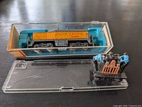 Locomotive in clear plastic case with handcar beside