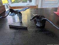 Both flying goose sculptures on tabletop, showing scale and form