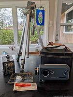 Group shot showing Kodak Instamatic M6 camera, Brownie Junior Six-20 camera, Velbon VG-3 tripod, leather case and manuals