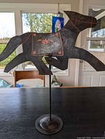 Full view of metal horse sculpture on stand