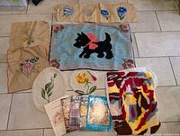 Overview of all rug hookings and four books laid out on floor