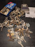 Pile of assorted keys, lock box, instructions visible