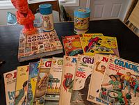 Group shot of comics, magazines, KFC bank, thermos and tin