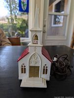 Front view of church showing steeple, doors, cord