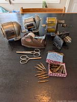 Overall lot showing three pencil sharpeners, tape dispenser, scissors and pen nib box