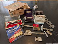 Overview of entire lot with razors, blade packs, oil can, wrench, cigar box