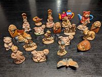 All twenty-two Tetley Tea ceramic figurines arranged on black surface