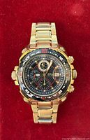 Front view of Daniel Steiger gold-tone chronograph watch on red background