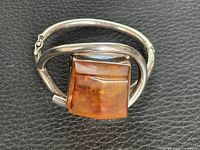Front view showing amber stone set in sterling silver bangle