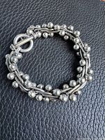 Full view of bracelet laid flat showing DNA motif and toggle clasp