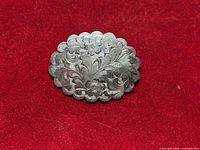 Front view showing engraved floral design and scalloped edge