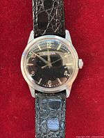 Front view of Bulova watch showing black dial, numerals, hands, and strap