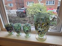 Pitcher and three goblets on windowsill showing size, colour and pattern