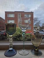 Front view of three hand-blown glass goblets showing colors, stems, and bowls