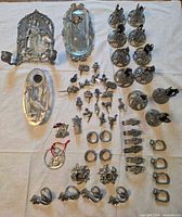 Entire lot laid out showing wall sconce, butter dish, heron tray, candlesticks, napkin rings, figurines and ornaments