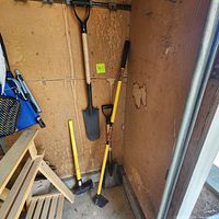Shovel, axe and hoe stored in shed corner