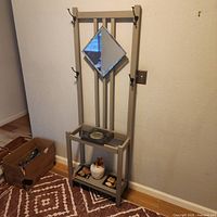 Full view of grey hall tree showing mirror, hooks and shelf