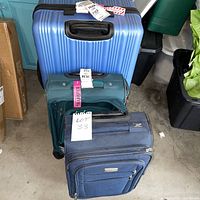 Stacked view of all three suitcases showing colors, types and wheels