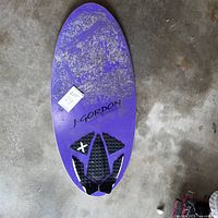 Full view of topside of purple J Gordon skimboard with traction pad