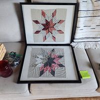 Two framed quilt star artworks, red glass votive, hardware bag partially visible