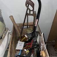 overall view of crate and contents including saws, mason jar, assorted tools