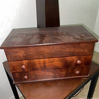 Closed dark wood jewelry chest on table
