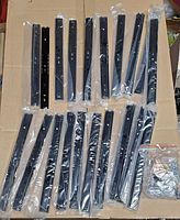 Individually wrapped black steel rails laid out on cardboard
