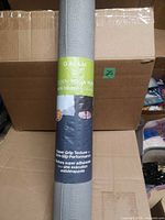 Rolled gray Gaiam yoga mat with full label visible