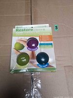 Front view of boxed Gaiam Restore Hand Therapy Kit showing three resistance balls