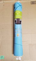 Rolled yoga mat front label showing brand and color