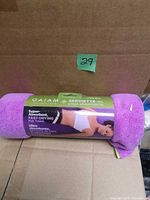 Rolled Gaiam microfiber yoga towel on cardboard background