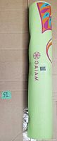 Rolled light green Gaiam yoga mat with printed graphic