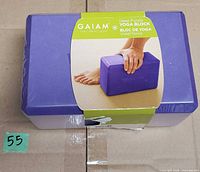 Front view of Gaiam purple yoga block in shrink wrap with sleeve