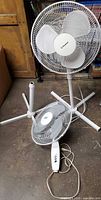 Two pedestal fan assemblies with heads, poles and bases
