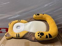 Top view of full tiger-shaped lounger showing mesh center pad and plush bolsters