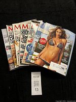 All seven magazines fanned out on black background showing spines and covers