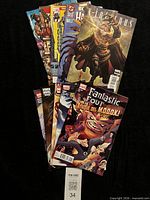Fanned stack of ten comic books showing covers and lot quantity