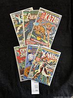 All six bagged Marvel comics fanned out on black background