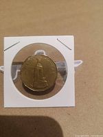 Coin reverse displaying National War Memorial inside holder