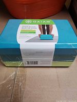 Factory-sealed tri-colour Gaiam yoga block showing label and packaging