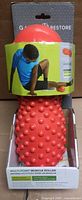 Front view of packaged orange spiked muscle roller in box